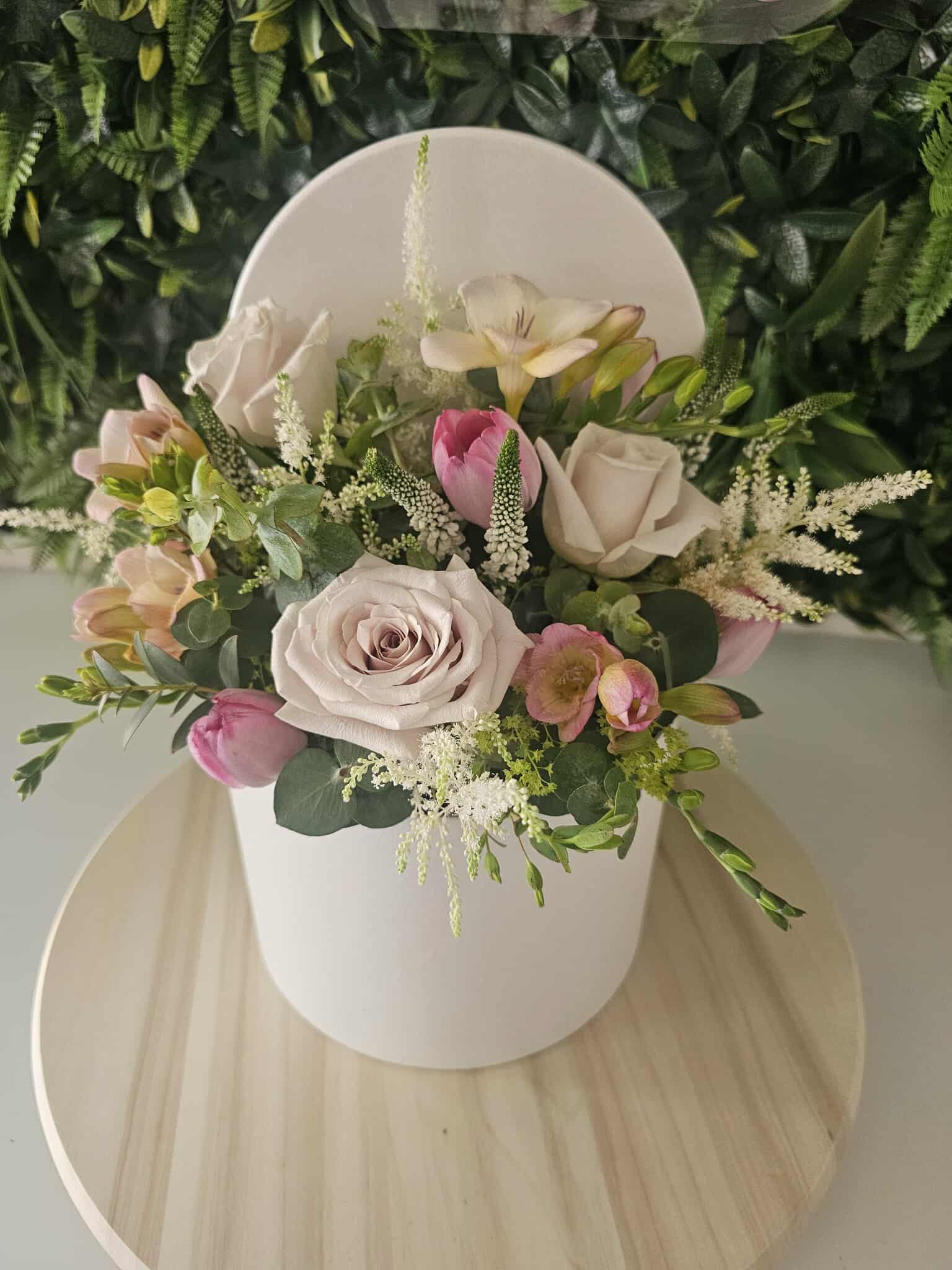 Soft blush flowers arranged in an elegant white hat box